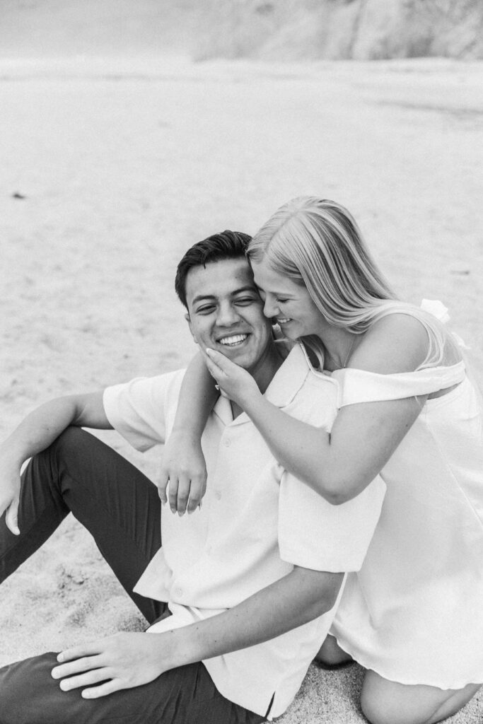 timeless B&W photo of a couple happily engaged on the beach