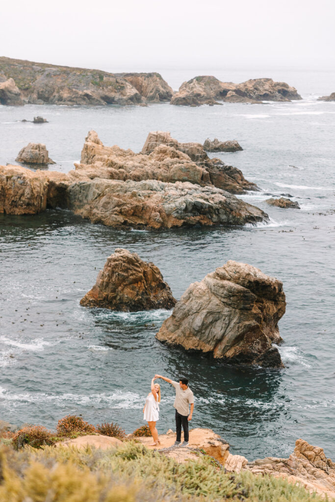 engaged couple twirling during their Big sur engagement photoshoot