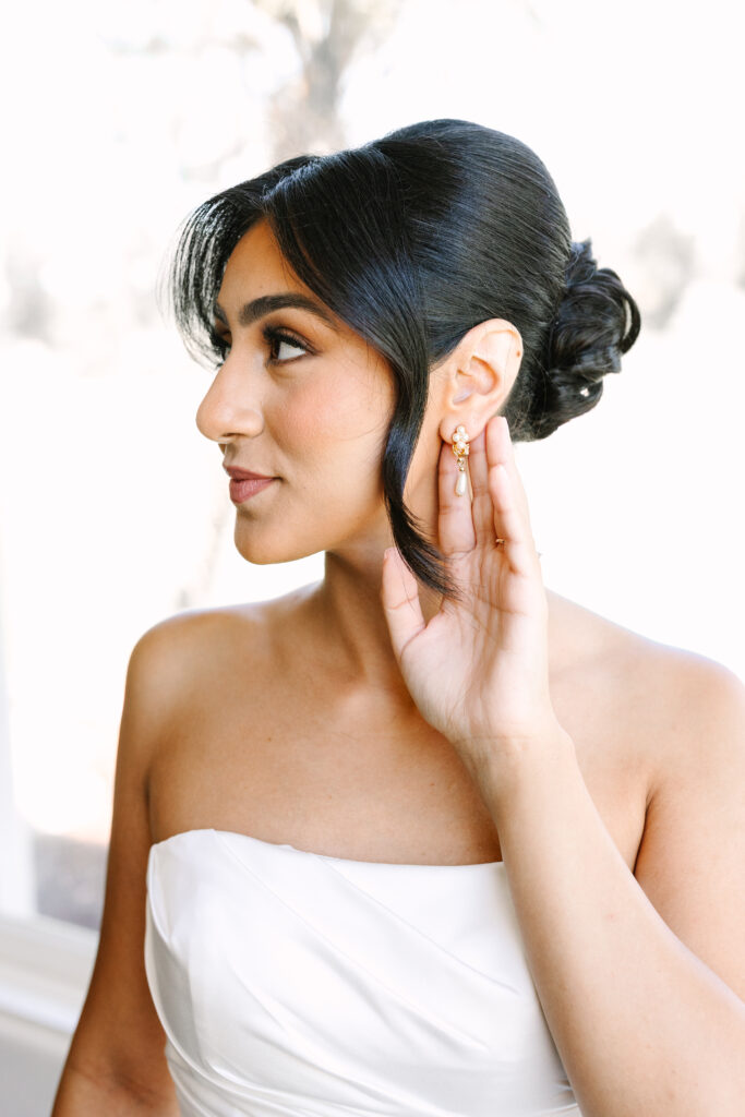 Bride putting on jewelry on her wedding day