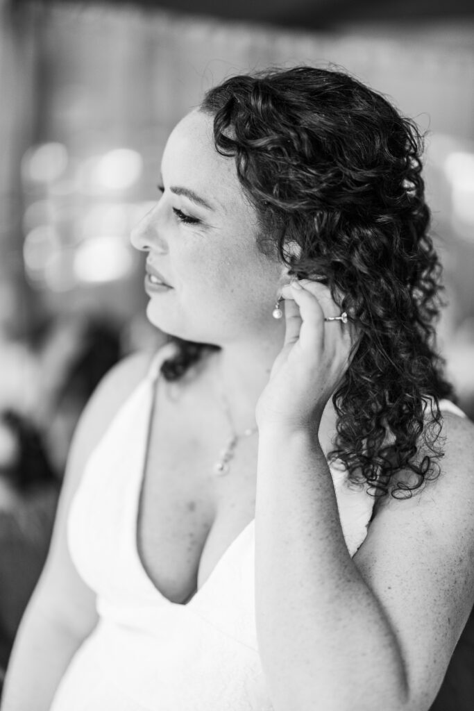 bride putting on her jewelry for her wedding at YMCA camp Campbell